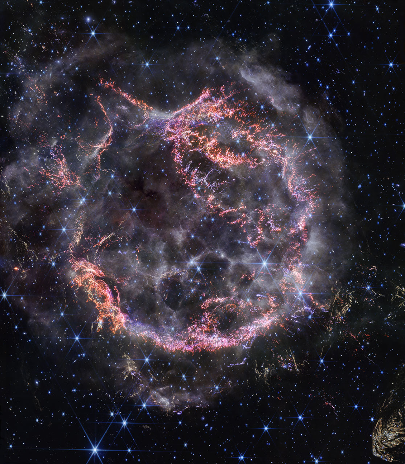 James Webb Space Telescope NIRCam image of Cassiopeia A, a supernova remnant with an inner shell of bright pink and orange filaments surrounded by curtains of wispy white gas